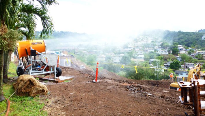 Construction site overlooking town with dust suppression cannon