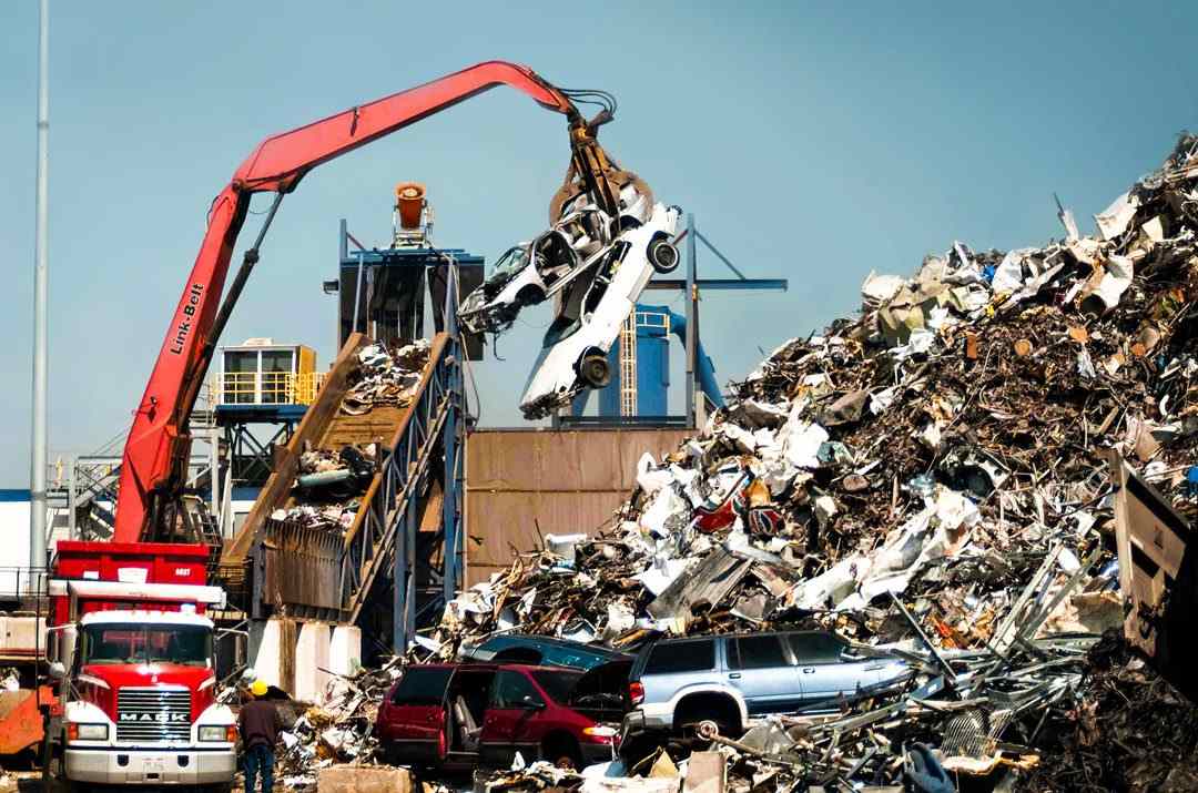 Scrap metal is being loaded onto a truck, highlighting dust control during recycling in the USA.