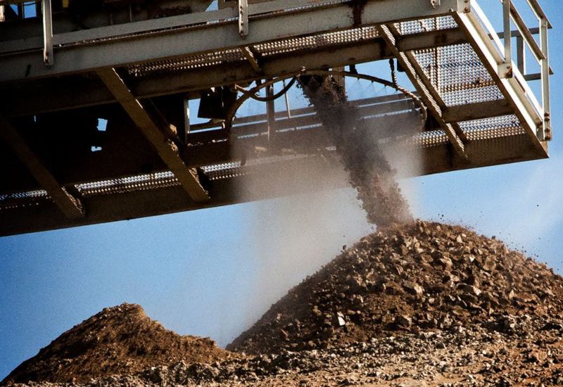 A conveyor belt is pouring rocks and gravel onto a large pile in the USA.